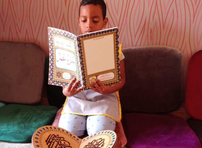 un enfant lit le coran